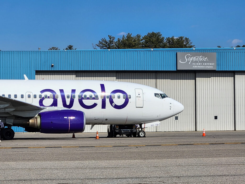 Photo of an Avelo Airlines aircraft in front of Signature Flight Support at Manchester-Boston Regional Airport